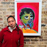 a woman standing in front of a painting of a woman